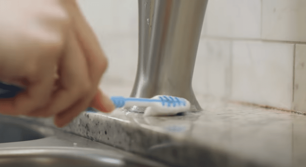 Uncover the faucet and clean its groves with toothbrush