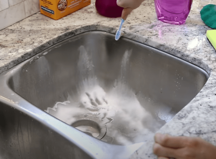 Use a toothbrush to deep clean tighter Spaces of the kitchen sink